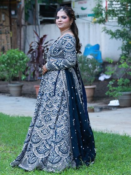 A side profile of the navy blue and silver lehenga, highlighting the detailed work on the blouse and the flow of the matching dupatta. This is a great option for bridesmaids or the bride's sister.