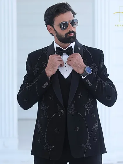 Adjusting the bow tie on our custom black tuxedo. Every element, from the lapel to the buttons, is chosen to create a cohesive and polished final look.