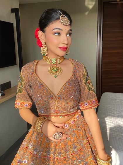 The complete look, with a sleek bun adorned with a red rose.