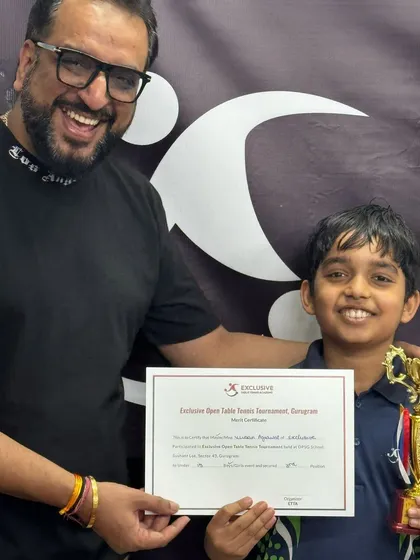 This is the moment it's all for. A huge smile from one of our young champions holding his well-earned trophy and certificate from our Exclusive Open Table Tennis Tournament. Seeing this joy is what drives me.