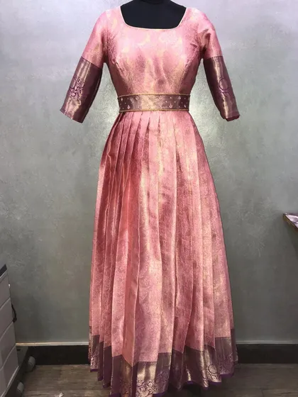 An elegant Anarkali gown made from a pink pattu saree. I carefully used the original saree border on the sleeves and hem for a complete, traditional look.