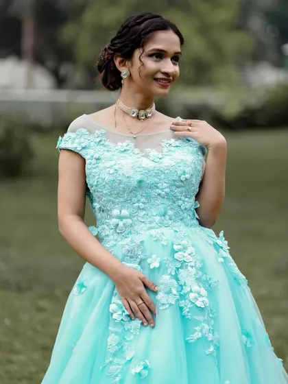 A closer look at the intricate 3D floral applique on the bodice of the light blue gown. These details add a layer of texture and craftsmanship to the dress.