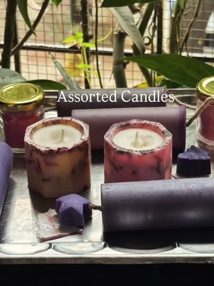 A beautiful assortment of our handmade candles on a silver tray. This collection includes various pillar candles, jar candles, and small heart-shaped melts, showcasing the variety I offer.