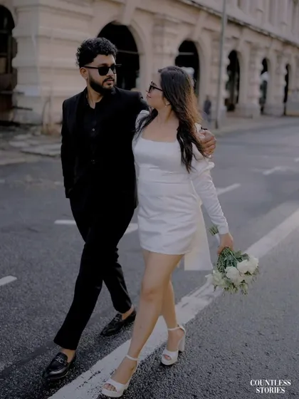 Walking arm in arm, they share a look that feels both candid and cool. This shot, taken as they cross the street, has a natural, unposed quality that I strive for in my urban pre-wedding photography sessions.