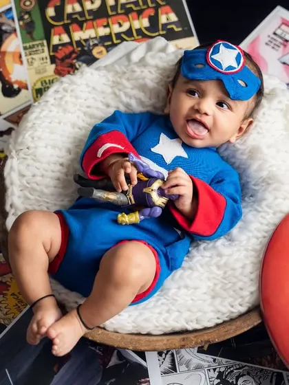 The cutest Captain America reporting for duty. This little hero is ready to save the day with his shield and a playful expression.