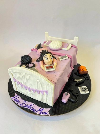 This custom "lazy girl" cake was so much fun to make. The entire scene, from the person scrolling on her phone in bed to the tiny makeup and hair tools on the floor, is made from detailed fondant work.