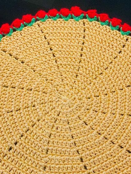 A yellow doily with a festive red tulip border. This color combination is great for celebrations.