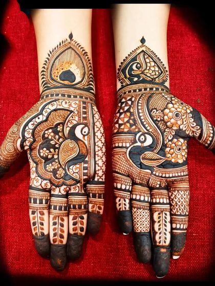 A beautiful peacock design for the palms, with intricate details on the feathers and delicate finger work.