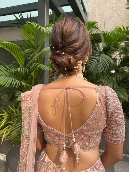 A close-up of the pearl-adorned textured bun. This style is perfect for a bride wearing a pastel lehenga, as it adds a touch of sophistication and romance.
