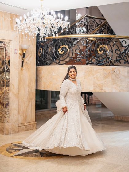 A dramatic twirl to show off the full glory of the Sangeet lehenga. The long jacket and flowing skirt create a beautiful silhouette, perfect for a grand entrance and a night of dancing.