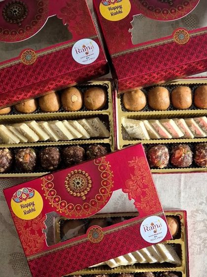 Assorted sweet boxes made for Rakhi. These hampers can be customized with a mix of sweets like Sattu Laddoos, Kaju Katli, and Ragi Laddoos to create the perfect gift for your brother.