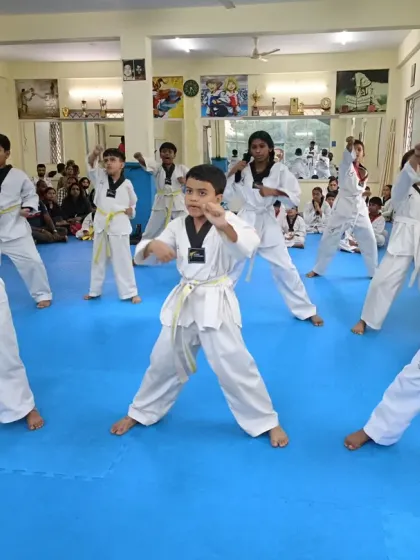 A class of white and yellow belts practicing their punches and kicks.
