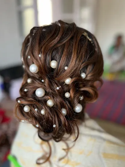 This view shows the volume and texture of the messy bun, with pearls scattered throughout like stars.