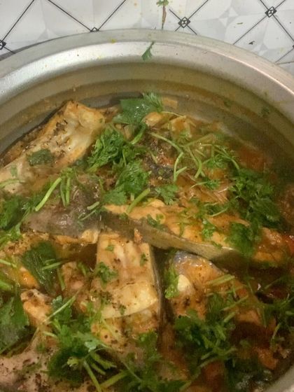 The fish curry after adding fresh coriander for garnish.