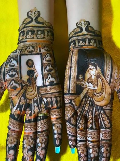 This Karwa Chauth design features portraits of women performing the festival's rituals. The top of the hands are adorned with graceful swan motifs.