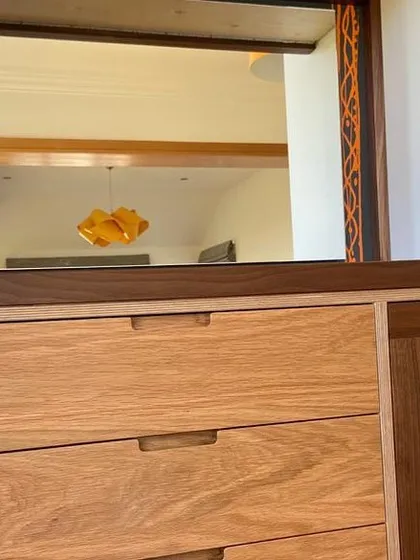 This detail shot highlights the contrast between the solid oak drawer fronts and the rich grain of the solid walnut worktop and frame. The integrated finger pulls provide a clean, handleless look.