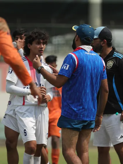 A moment of intense discussion between our coaches and a player during a match. We believe in constant communication and guidance.