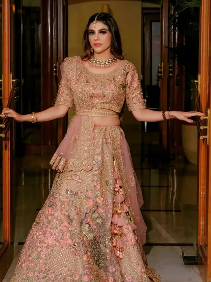 A grand entrance shot, showcasing the beautiful details and tassels of this pink rental lehenga.