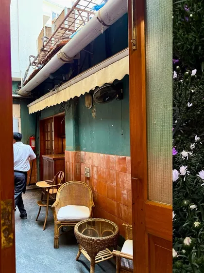 The quiet, charming back alley of a cafe in Kala Ghoda, with its wicker chairs and tiled walls.