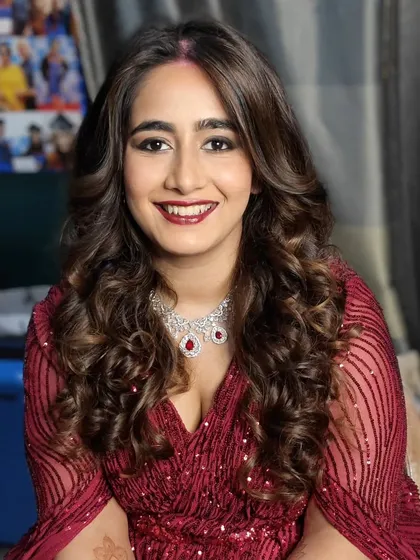 This bride is absolutely radiant for her reception. We chose a glamorous look with voluminous curls and a striking red lip, ensuring she looked and felt like a star.