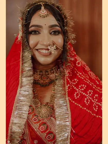 A happy portrait of the bride, showcasing her complete traditional look with layered jewellery and a bright smile.