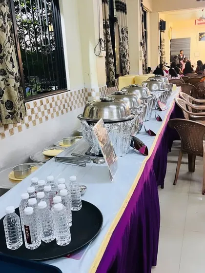 Another angle of the indoor buffet setup, showing water bottles and other arrangements ready for the guests.