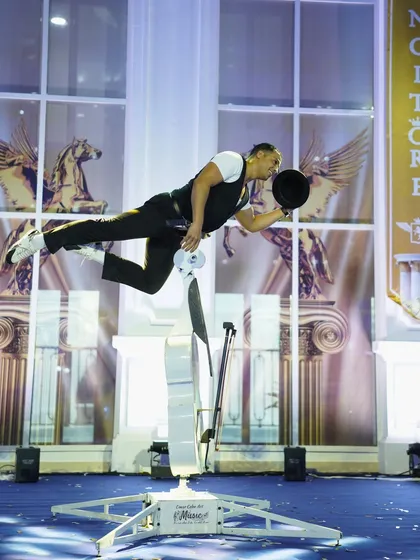 The climax of the cello act, with the performer balancing horizontally on the instrument, a moment of pure theatricality.