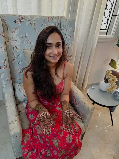 A lovely portrait of the client, happy with her intricate and meaningful mehndi design for her special day.