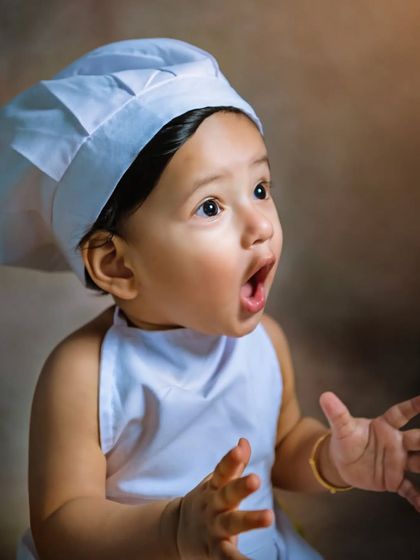 The look of pure amazement! Dressed as a little chef, this baby's wide-eyed wonder is a perfect example of the candid expressions I love to capture.