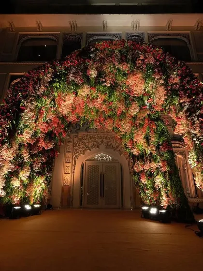 A grand floral archway provides a breathtaking entrance to the wedding venue. This is how I set the stage for a celebration of grandeur and elegance.