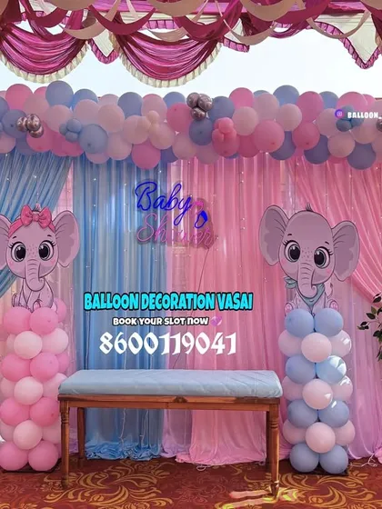 A detailed view of the elephant-themed baby shower backdrop. The combination of balloon columns, floral arrangements, and character cutouts creates a full and festive stage.