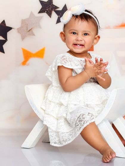 Clapping her hands with glee, this little one is the star of the show in our whimsical "Moon and Stars" setup.