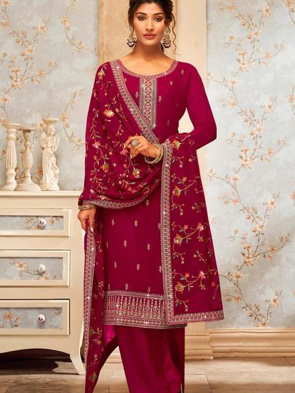 This magenta salwar kameez is vibrant and full of life. The heavy thread embroidery and mirror work make it a festive favorite.