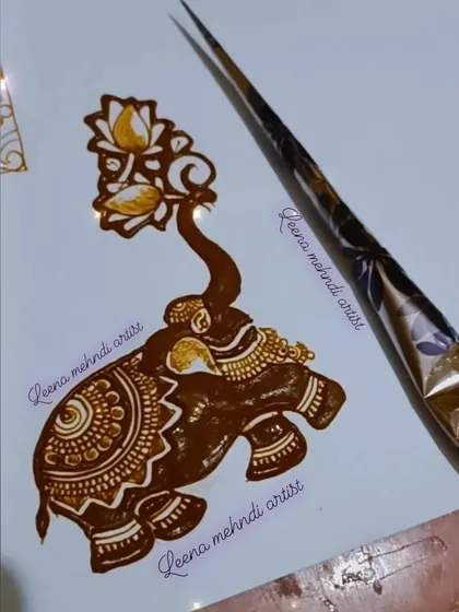 A detailed elephant motif with its trunk holding a lotus spray. This is a beautiful and auspicious design element for any traditional mehndi.