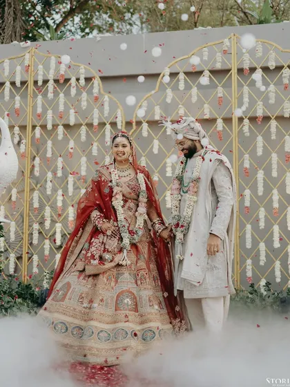 Kunal and Parul sharing a happy moment after their Varmala, surrounded by smoke effects that add a touch of magic.