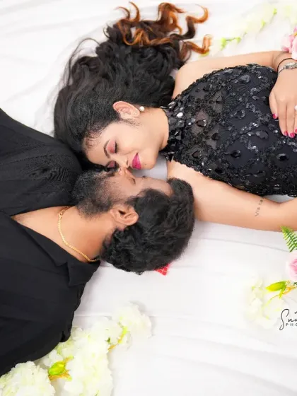 An intimate top-down shot of a couple in black, surrounded by flowers. This artistic angle captures their close connection and the romance of the moment.