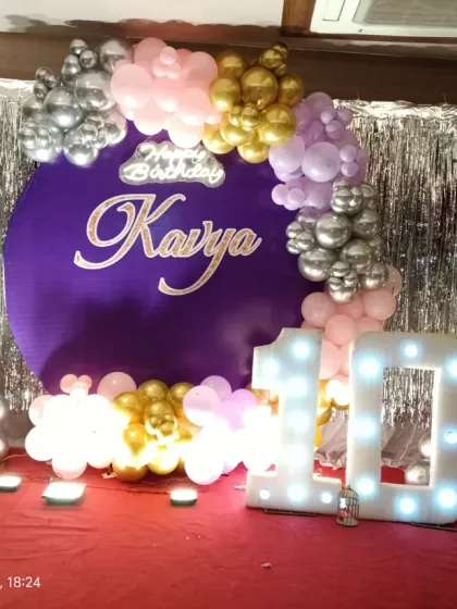 Another angle of the 10th birthday setup, highlighting the shimmer wall and balloon arrangement on a red carpet stage.