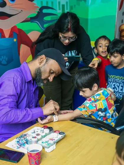 Getting creative with a temporary tattoo. This is one of our popular party add-ons, where a professional artist creates fun, kid-friendly designs for all the little guests.