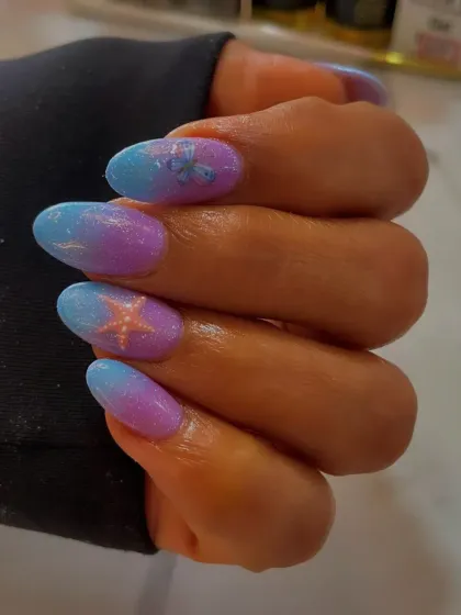 A dreamy mermaid-inspired ombré effect. These almond nails feature a beautiful gradient of purple and blue, with delicate starfish and butterfly art.