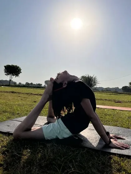 A student in a deep backbend, the full cobra pose, under the open sky. This pose is incredible for opening the heart and strengthening the back.