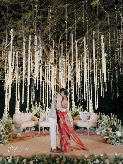 I believe in capturing the magic of your celebration in its entirety. This photograph shows how I frame your love story within the breathtaking ambiance you've created, turning a wide shot of the decor into an intimate portrait of connection under a canopy of lights.