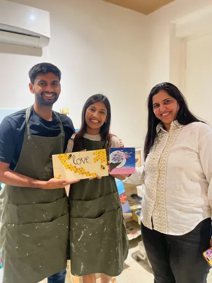 A couple and their friend pose with their finished artworks. Our sessions are great for small groups looking for a fun and different kind of hangout.