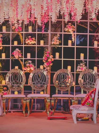 The intricate details of the mandap seating, featuring custom chairs and a backdrop of beautiful flowers and candles, creating a luxurious and intimate setting.