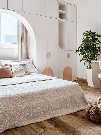 The daughter's bedroom is an understated, pale-toned haven with a custom-designed wardrobe and study table that incorporate playful arched forms.