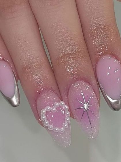 A dreamy, futuristic set with silver chrome French tips and a 3D pearl heart accent nail.