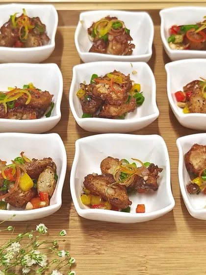 Bite-sized portions of our crispy salt and pepper chicken, served in individual white bowls. A savory and satisfying appetizer for any event.