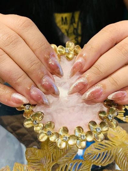 A subtle yet stunning set of stiletto nails with a sheer base and a light gold cat eye effect.