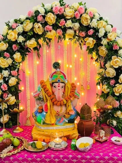 A lovely floral arch of yellow and pink roses with a backdrop of pink drapes and fairy lights. This warm and cheerful design is perfect for creating a happy and inviting atmosphere.
