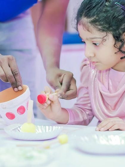 A close-up of a child participating in a pot painting workshop. My team is always on hand to assist and guide the little artists.