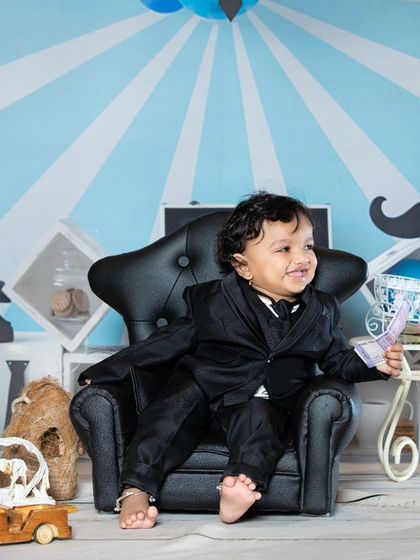 A happy boss baby enjoying his time in the big chair.